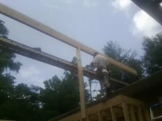 Carpenter setting a ridge beam over a new addition frame — Ice Dam Removal by Roofing Brothers in Aspinwall