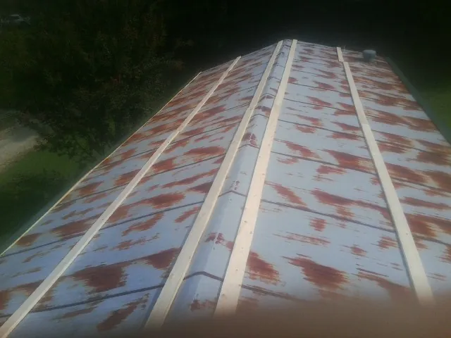 Rusted metal roof panels with new wood purlins before replacement — Storm Damage Roof Repair in Aspinwall by Roofing Brothers