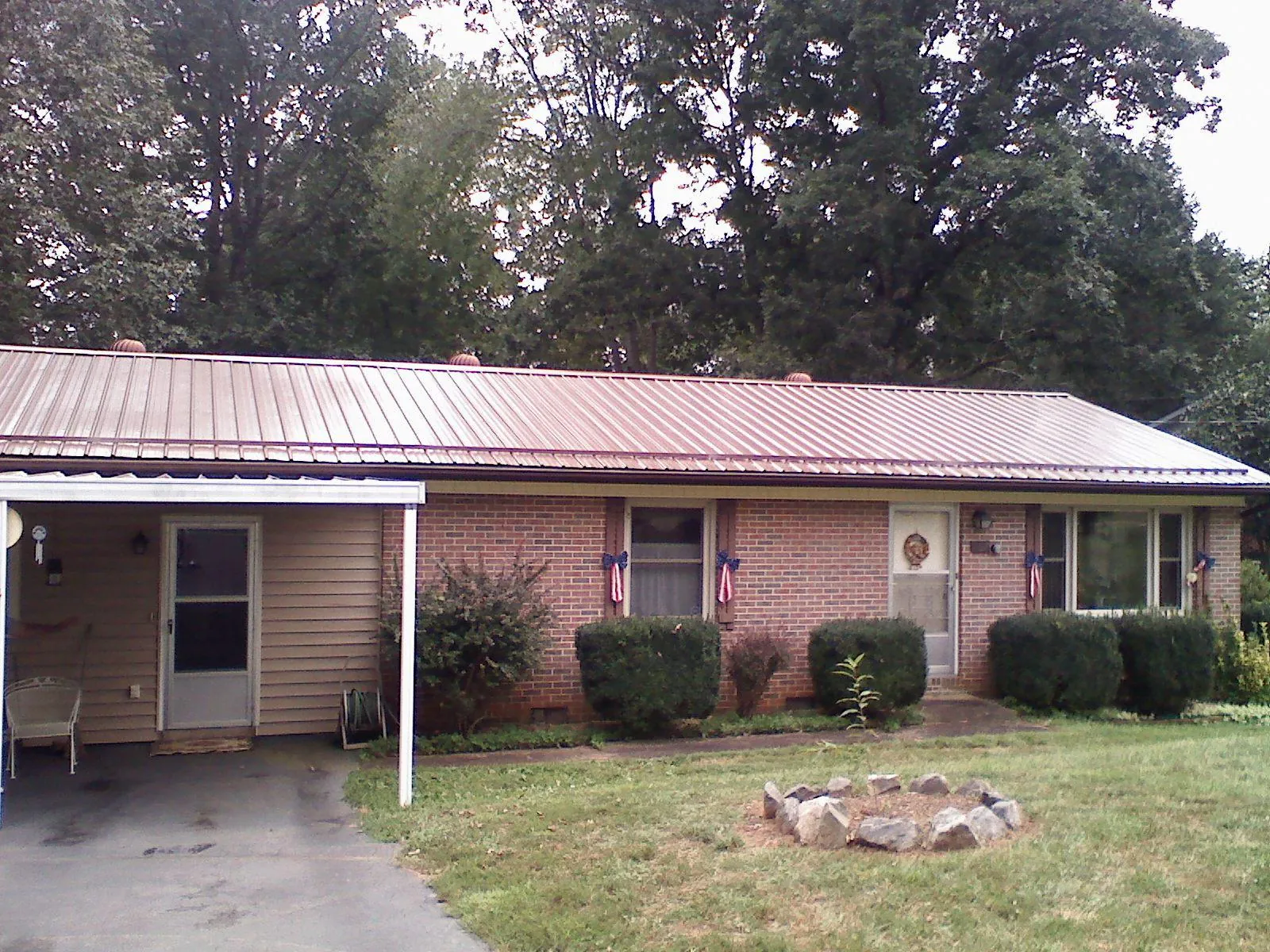 Bronze metal roof and carport on a brick ranch home — Roof Repair work by our crew in Aspinwall